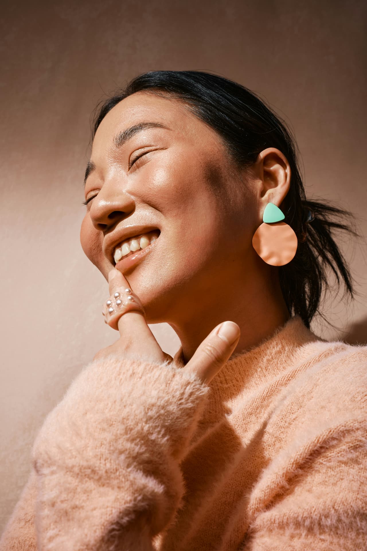 Smiling woman with statement earrings in warm sunlight