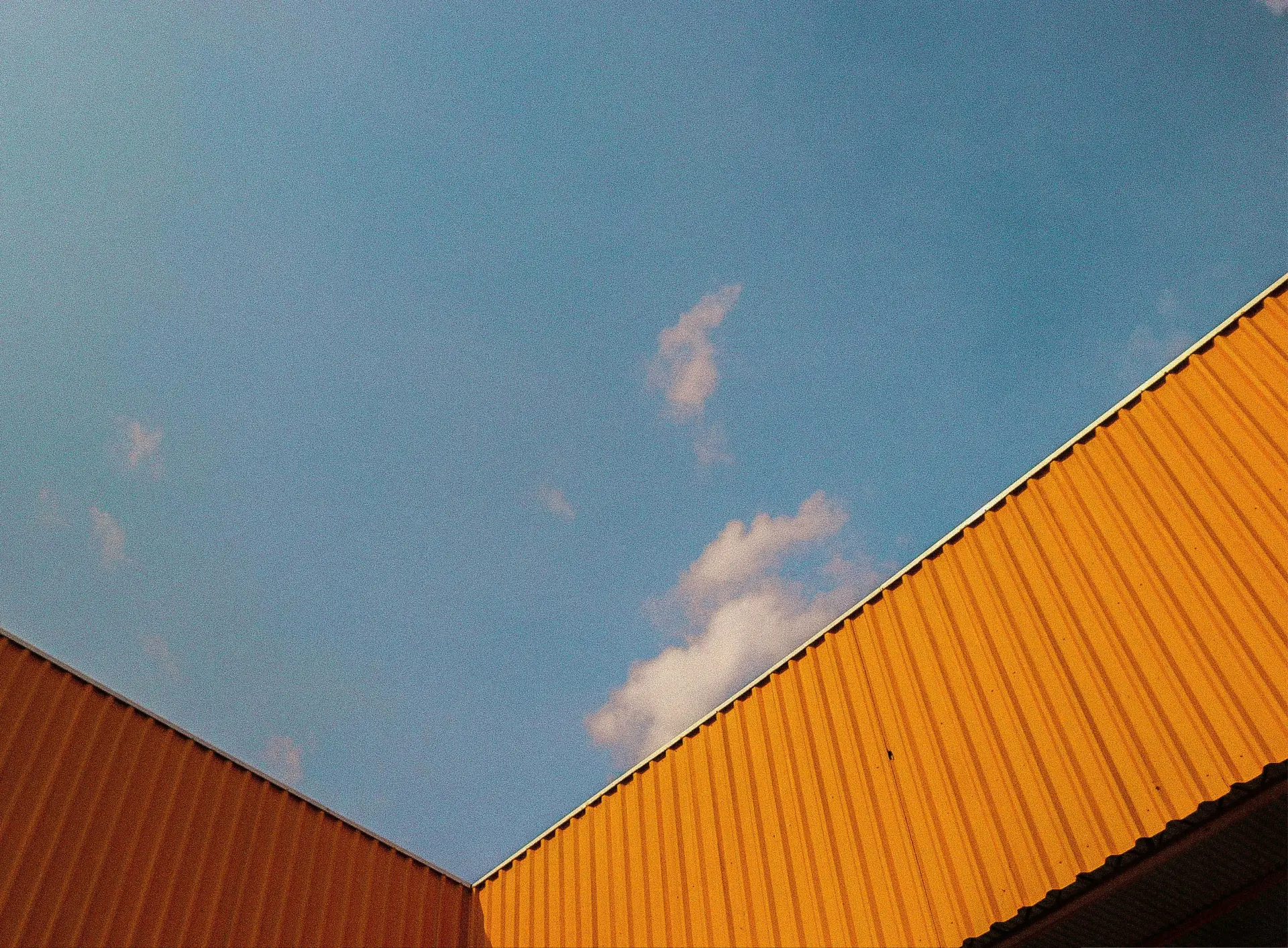 Warehouse rooftops against a blue sky