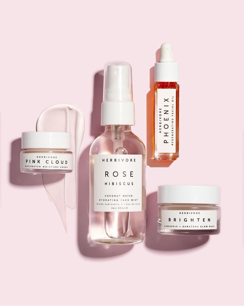 Herbivore Botanicals Pink Cloud, Rose Hibiscus mist, Phoenix facial oil and Brighten mask on a pink background