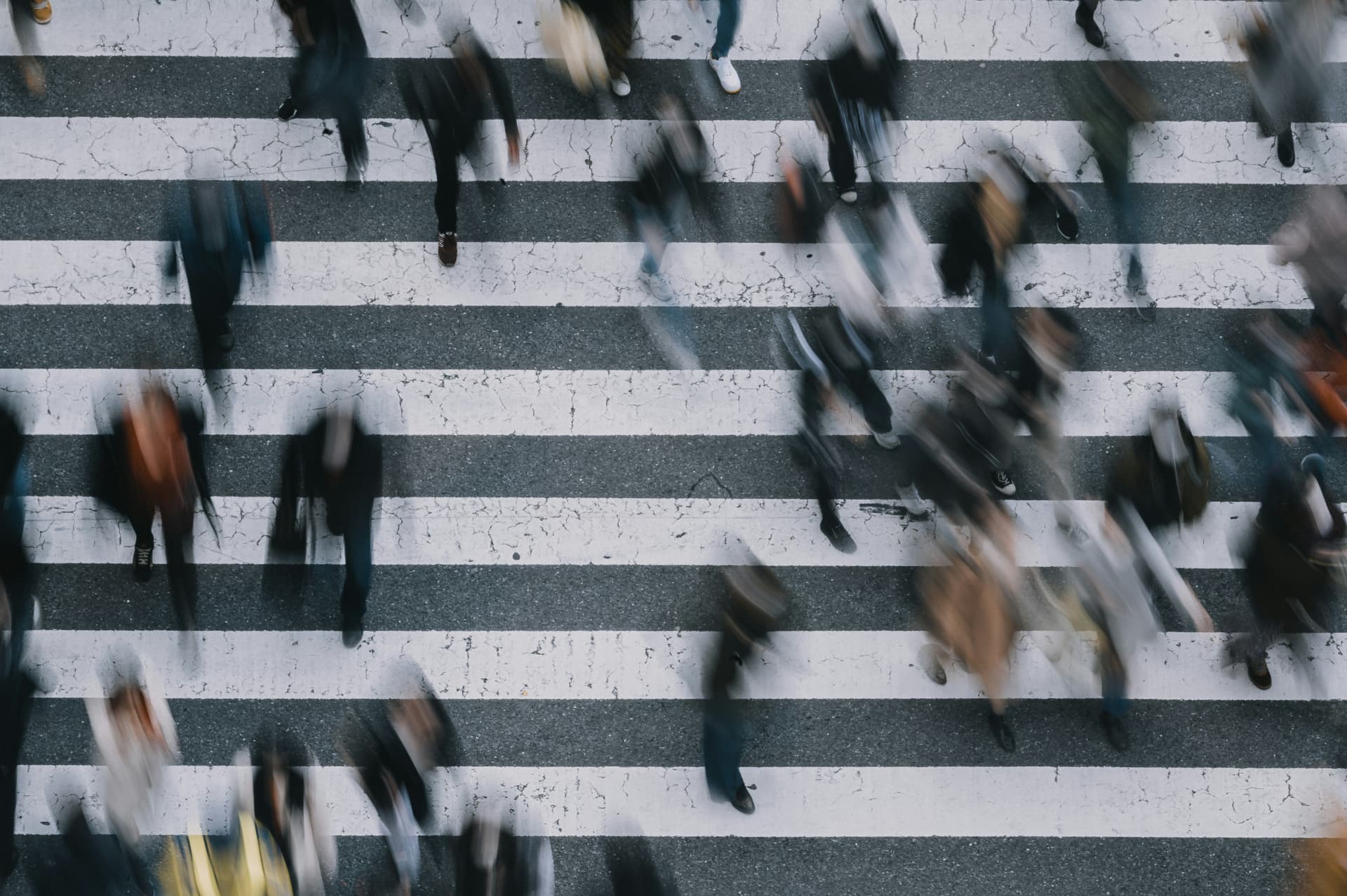 Crowds walking across a pedestrian crossing